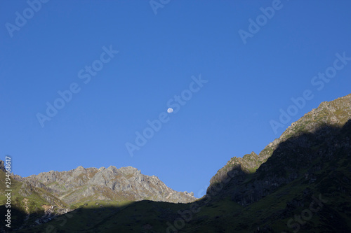 Landscape with mountains and moon on blue sky. Nature, travel concept