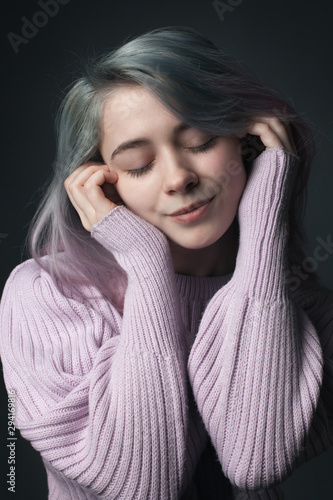 Girl with dyed hair siles with closed eyes