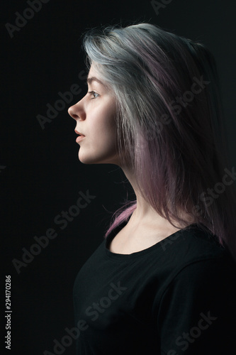 Portrait of young woman with blue and violet hair. Profile.