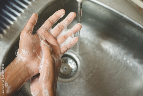 closeup of a boy scrubbing soapy hand against washbasin. Concept of a hand hygiene and global handwashing day