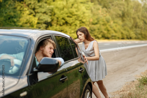 Young woman pushing broken car with man on road © Nomad_Soul