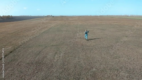A boy with an airplane in his hands runs in the park aerial video