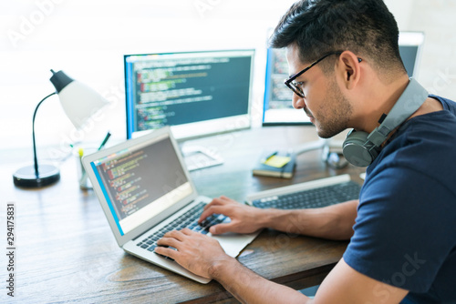 Fototapeta Handsome Young Male Programmer Coding On Laptop