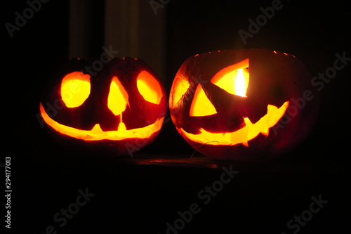 Halloween pumpkin head jack lantern on dark grass background