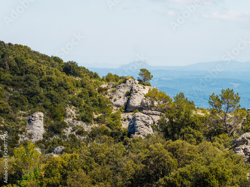 Paysage de Provence. Montée vers le Gros Bessillon par la route de la crête bordée par de gros rochers dont la Roche Trouée et la Gorge de Cinq heures