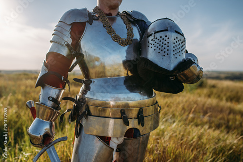 Fotografia Knight in armor and helmet holds sword