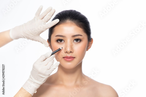 Lines on face, close up, plastic surgery concept, doctor's hand in glove making marks on patient's face..Asian beauty Woman in beauty salon. plastic surgery clinic.