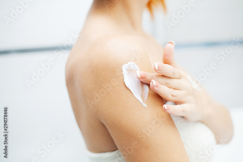 Skin care. Woman use skin care products at home in light bathroom