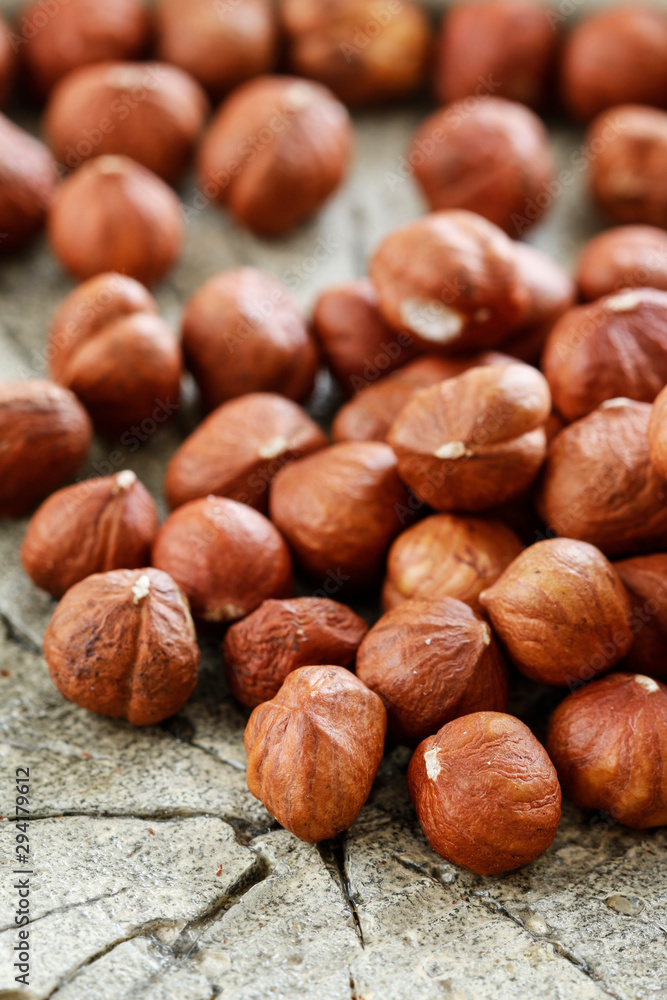 Hazelnuts on rough wooden background.