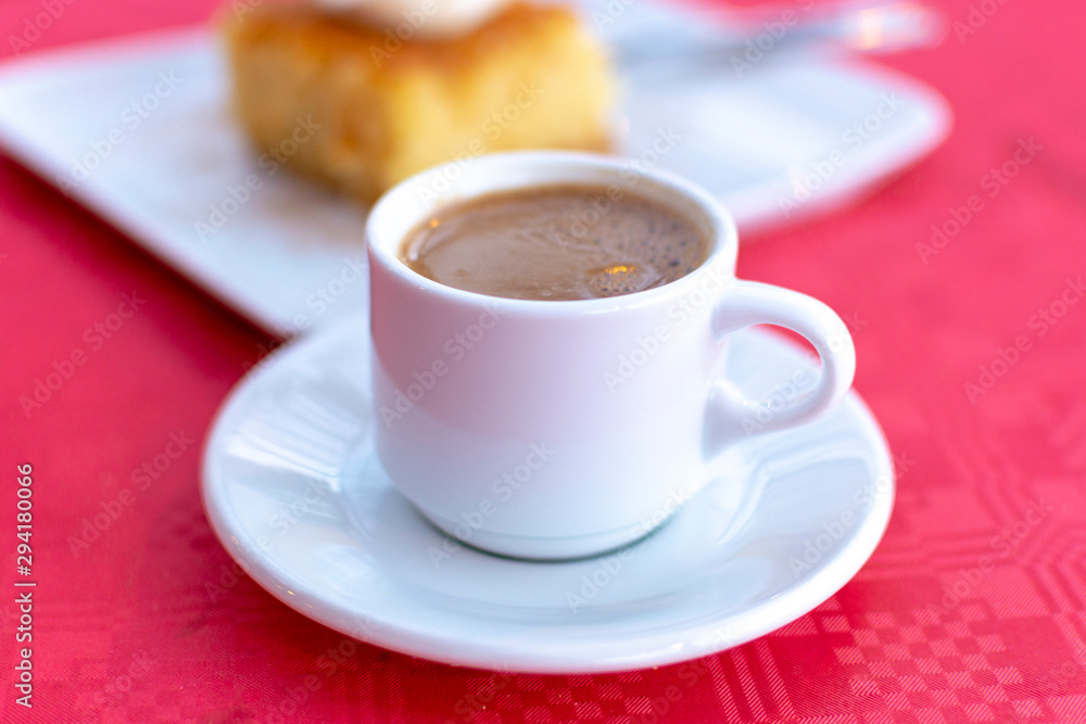 Traditional greek coffee served in white coffee set in cafe Traditional greek coffee served in white coffee set in cafe