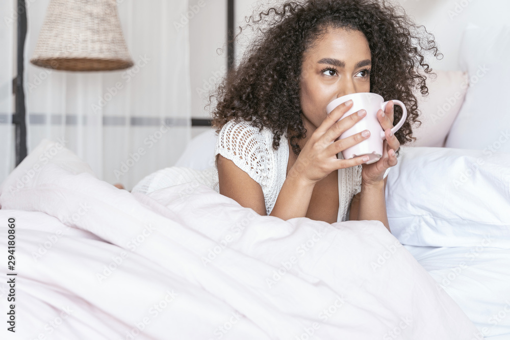 Amazing international girl drinking tea in her bed