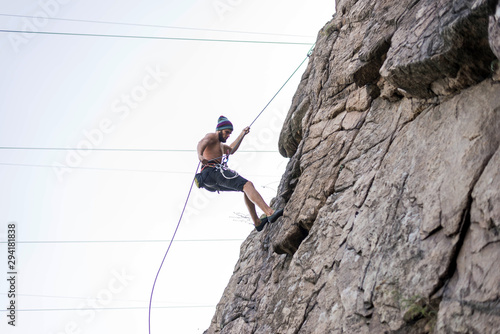 Man climber climbing down the rope active lifestyle.