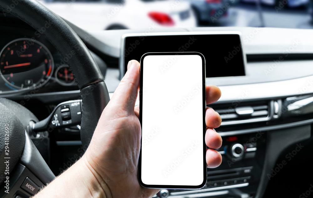 Male hand using smartphone in car. Man driving a car. Smartphone in a car use for Navigate or GPS. Mobile phone with isolated white screen. Blank empty screen. copy space. Empty space for text.