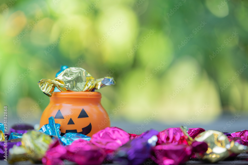 Fototapeta premium Halloween jack-o-lantern pail with spilling candy