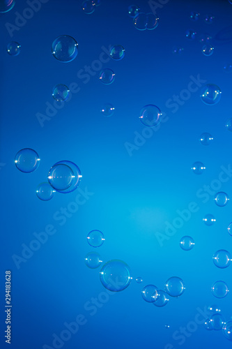 Soap bubbles float on blue background