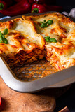 rustic spicy lasagne with basil on the tin.