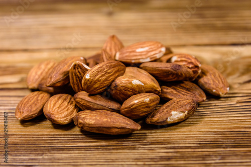 Heap of the peeled almond nuts on wooden table photo