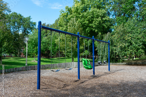 Blue Swing Set at a Playground during the Summer with Green Trees