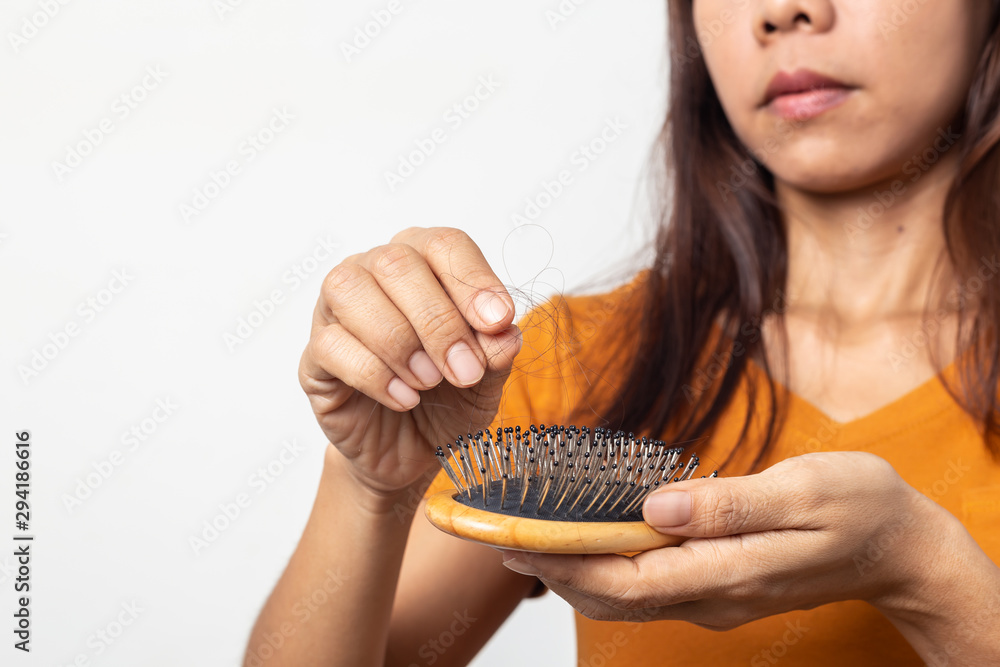 young asian woman worried about hair loss on a white background,Haircare concept young asian woman worried about hair loss on a white background,Haircare concept