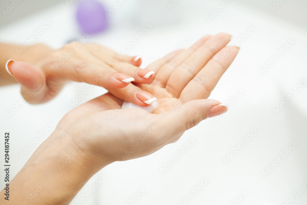 Skin care. Woman use skin care products at home in light bathroom