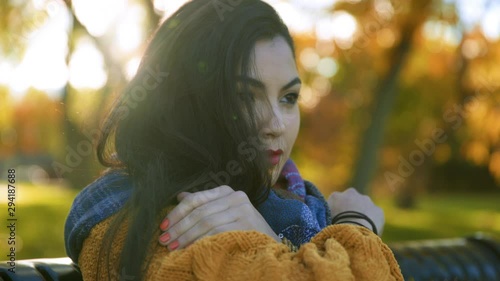 Girl thinking in a park hugging herself photo