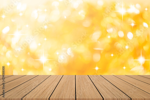 abstract blur beautiful gold color and glittering bokeh light background with modern brown wood tabletop for show ads design product on display in the christmas festival and happy new year season