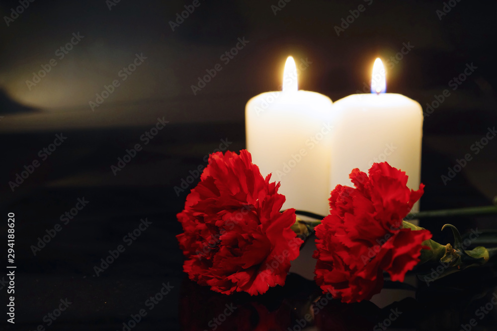 Two burning candles with flowers.