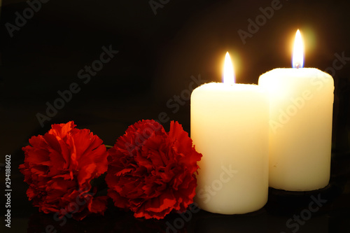 Obraz na płótnie Two burning candles with flowers. w salonie