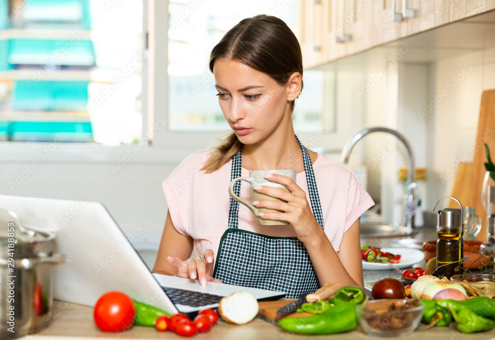 Female using her laptop at kitchen