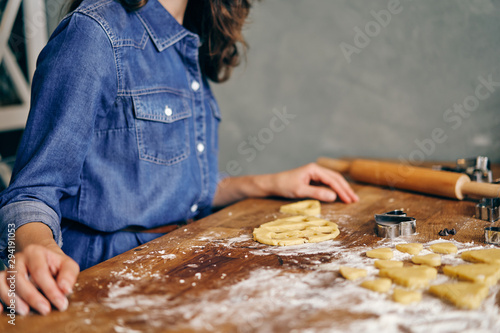 Young adult woman cooking holiday cookies in winter season at home