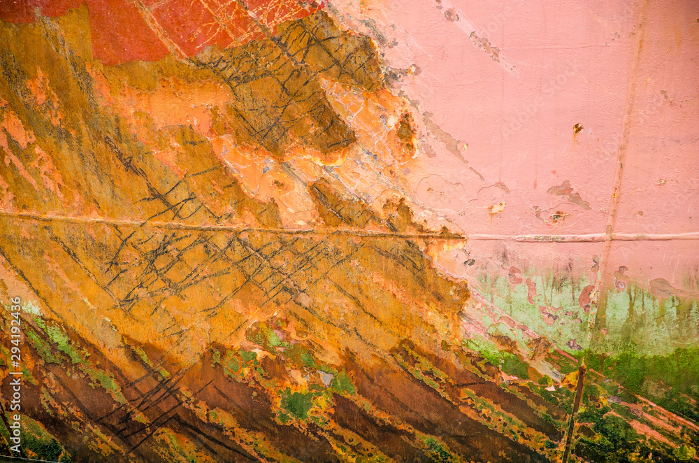 Past of a ship's hill, heavily weathered, with two welding joints, scratches, grunge, rust and several layers of peeling paint in various colors