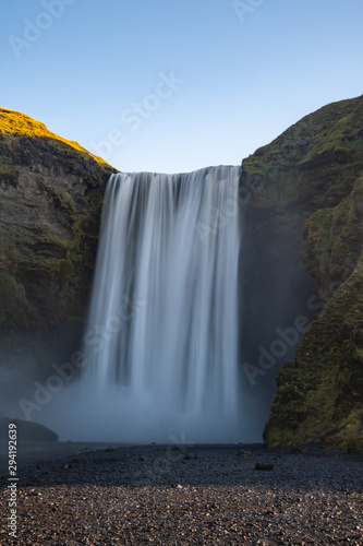 Skogafoss waterfall in Iceland on a beautiful summer day with blue sky in the back.