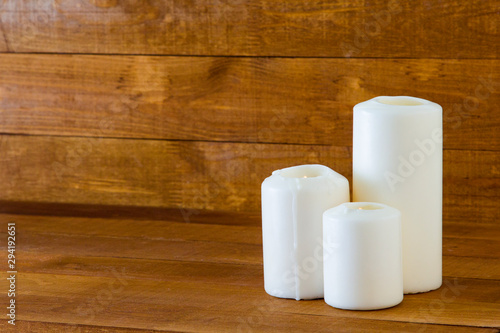 Large white candles on a wooden table