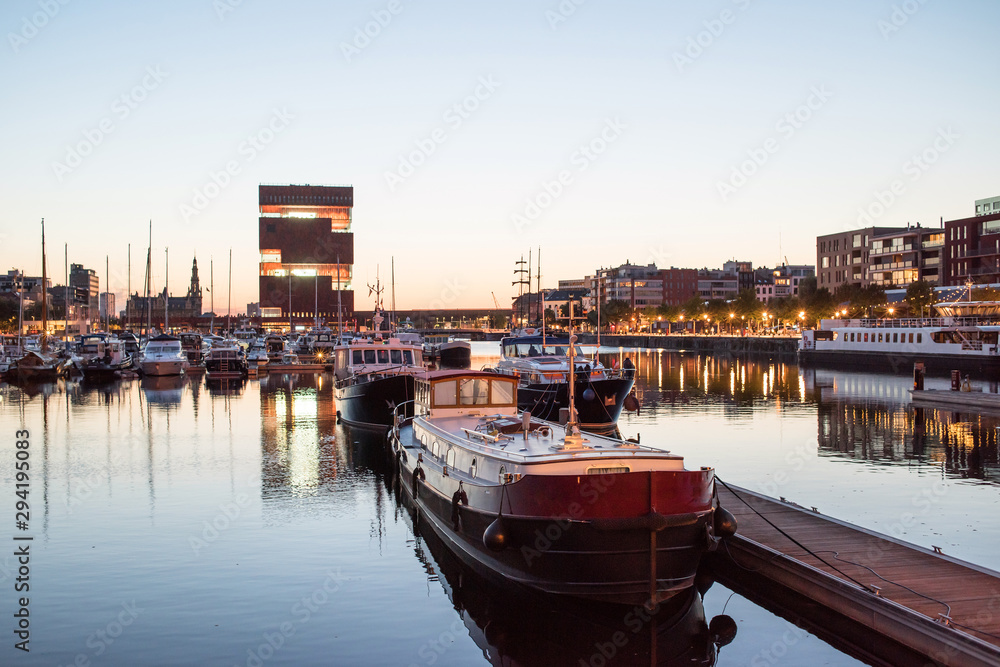 Night view of modern Eilandje area and port in Antwerp, Belgium. Small island district and sailing marine at sunset. Popular travel destination and tourist attraction