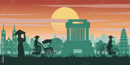 Vietnamese woman and man ride bicycle pass landmark of Vietnam,vintage color with sunset time tone