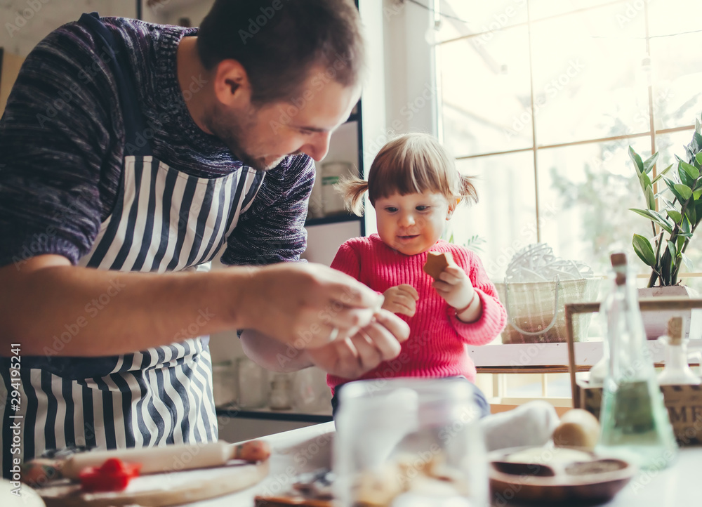 Happy family in the kitchen. Father and daughter are preparing the christmas cookies. Happy family in the kitchen. Father and daughter are preparing the christmas cookies.