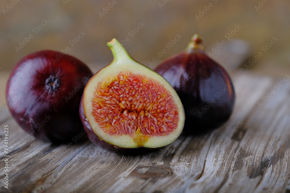 Fresh ripe figs and cut in half on a wooden table. Fresh ripe figs and cut in half on a wooden table.