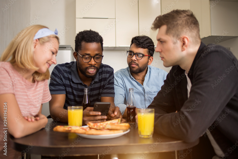 Young friends having party at home, eating pizza