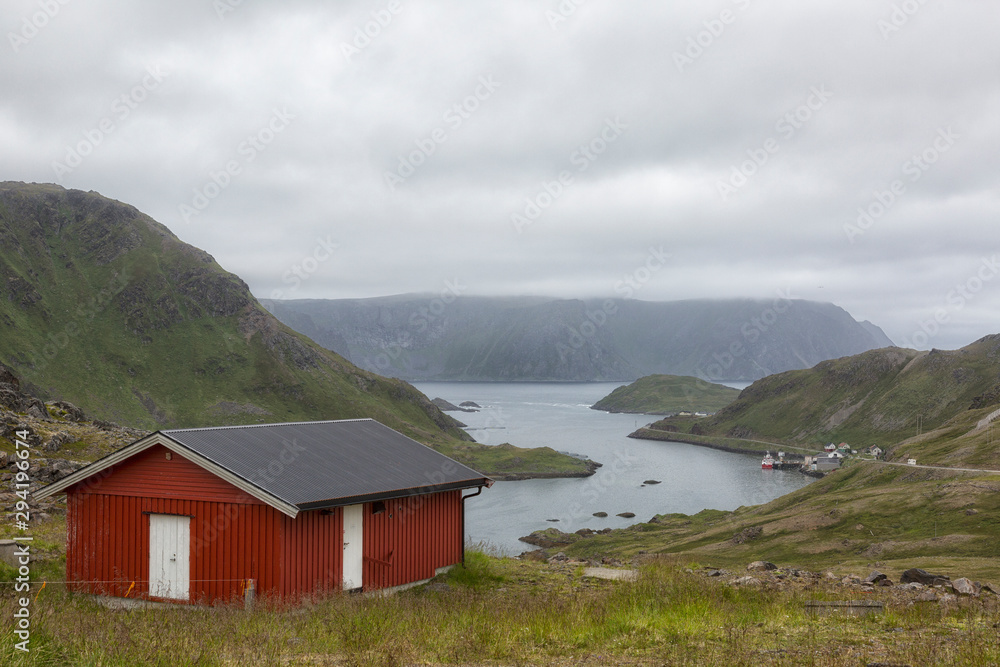 Traditional Norwegian house on the fjord in cloudy weather