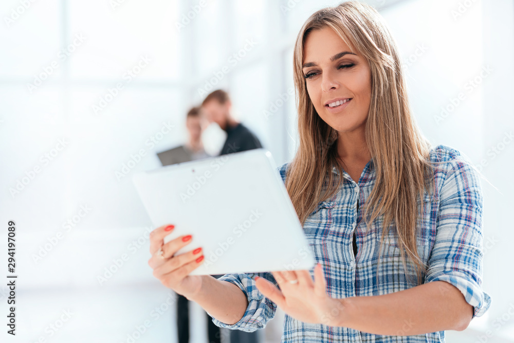 young businesswoman uses a digital tablet standing in the office. young businesswoman uses a digital tablet standing in the office.