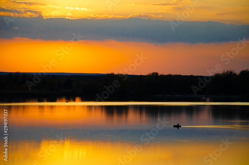 sunset on the lake and the boatman swims