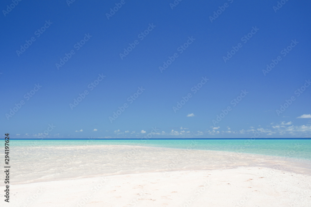 Landscape of a white sandy beach leading into turquoise waters under a blue sky on the island of Fakarava in French Polynesia Landscape of a white sandy beach leading into turquoise waters under a blue sky on the island of Fakarava in French Polynesia