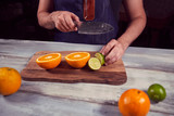 Young chef in kitchen holding knife and preparing juice. Food concept.
