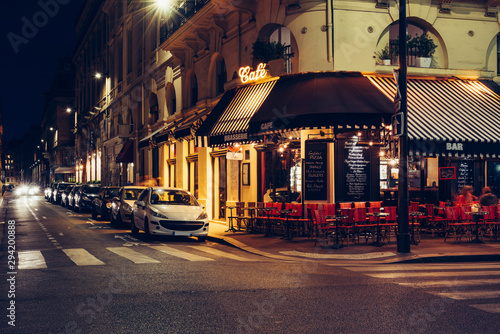 Fototapeta Naklejka Na Ścianę i Meble -  Cozy street with tables of cafe in Paris at night, France