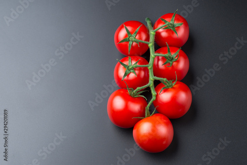 Beautiful red tomatoes on a black background, close up. © Oleh