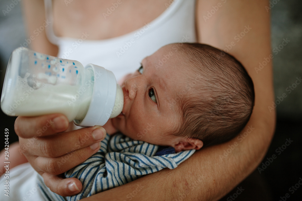 Closeup portrait of 1 month old baby eating milk from bottle Closeup portrait of 1 month old baby eating milk from bottle