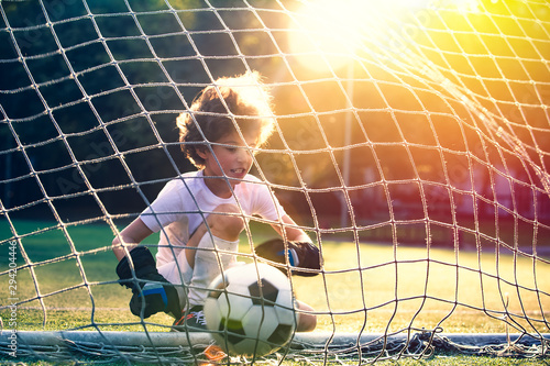 Disappointed football team goalkeeper following goals. Goalkeeper emotionally reacts after missed goal during game. Defeat Concept