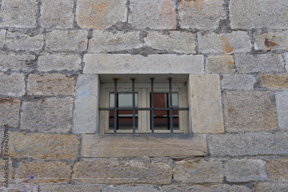 Vergittertes Fenster in alter Steinmauer