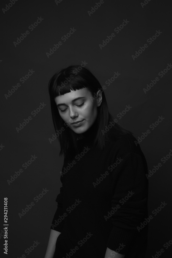 Portrait of sad attractive young woman. Low key. Black and white