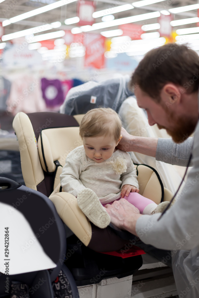 Obraz premium Dad with baby in store buying car seat.